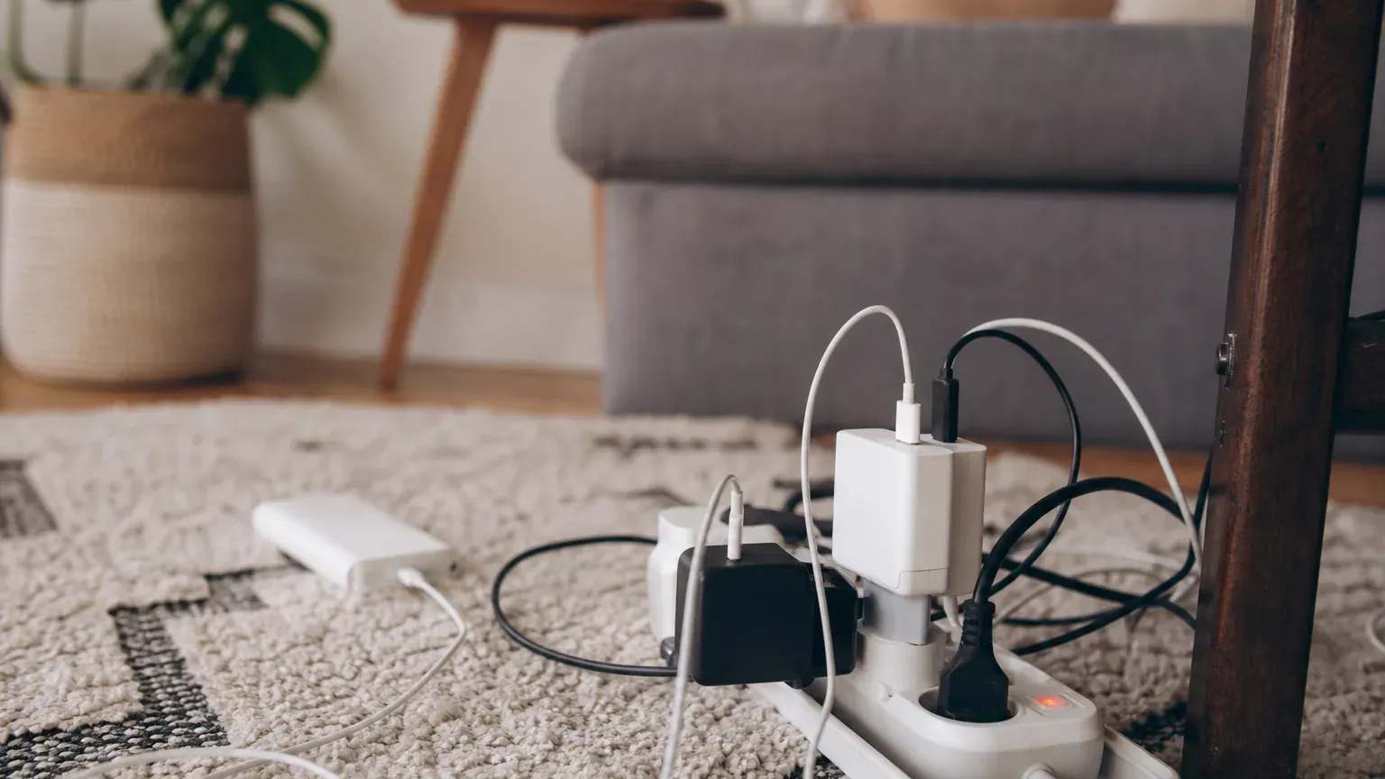 Multiprise avec plusieurs appareils électroniques branchés dans un salon