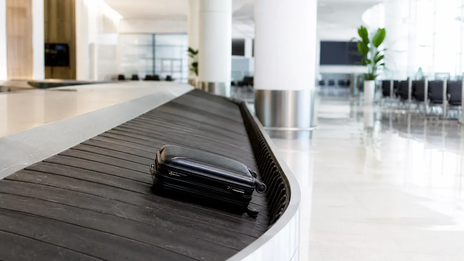Valise seule sur un tapis roulant de récupération des bagages à l'aéroport