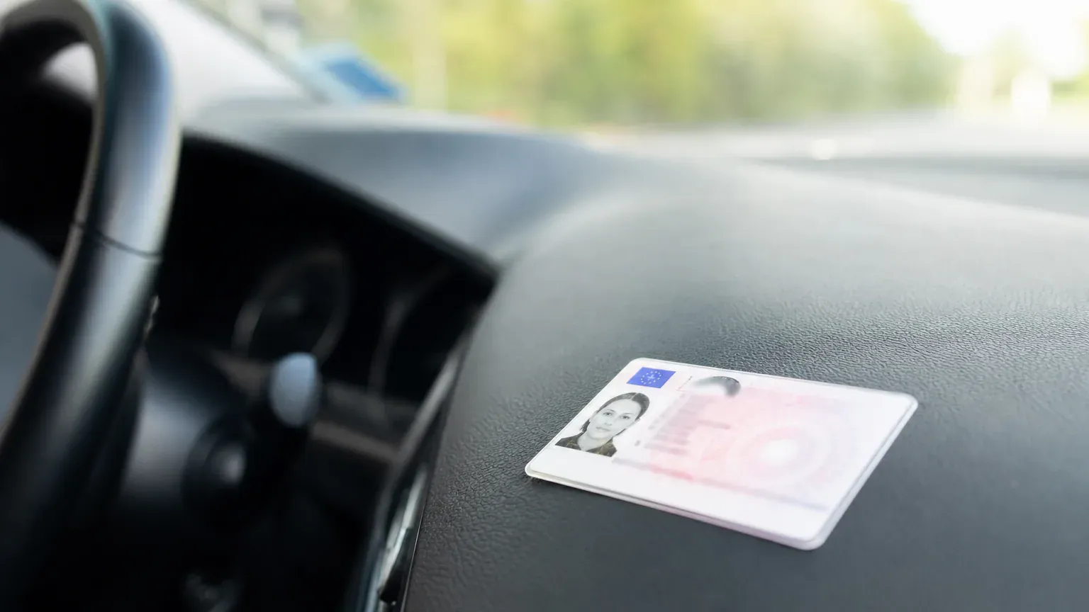 Permis de conduire français posé sur le tableau de bord d'une voiture