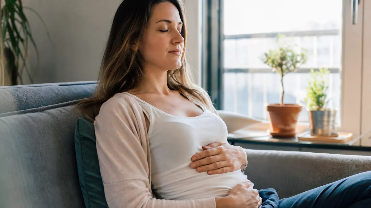 Personne assise qui respire calmement, une main sur le ventre, pour apaiser une crise d'angoisse