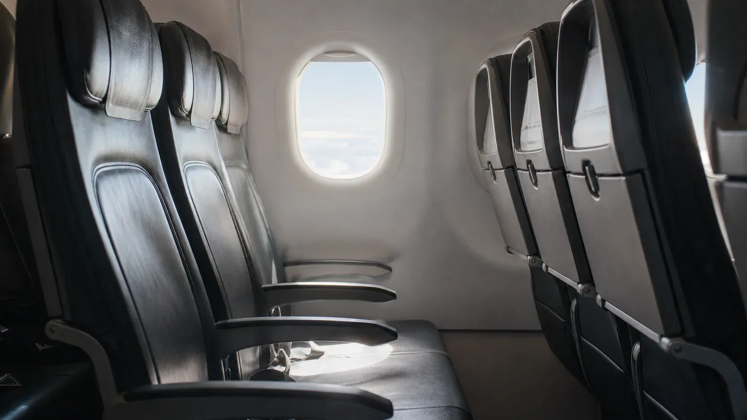 Intérieur d'une cabine d'avion avec des sièges vus depuis l'allée