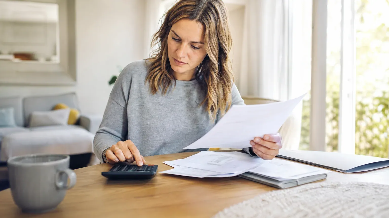 Personne consultant des documents de prêt et une calculatrice sur une table