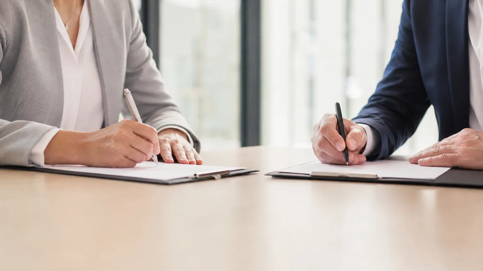Employeur et salarié signant les documents d'une rupture conventionnelle